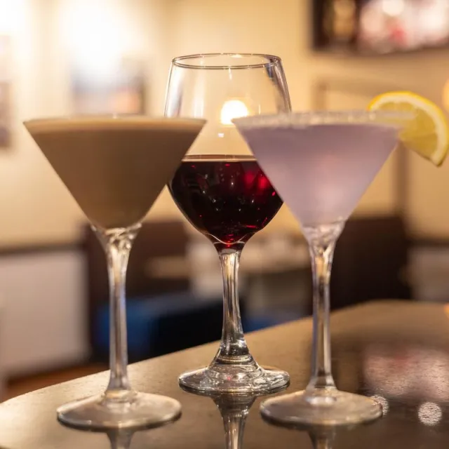 Martinis and a glass of red wine on the bar